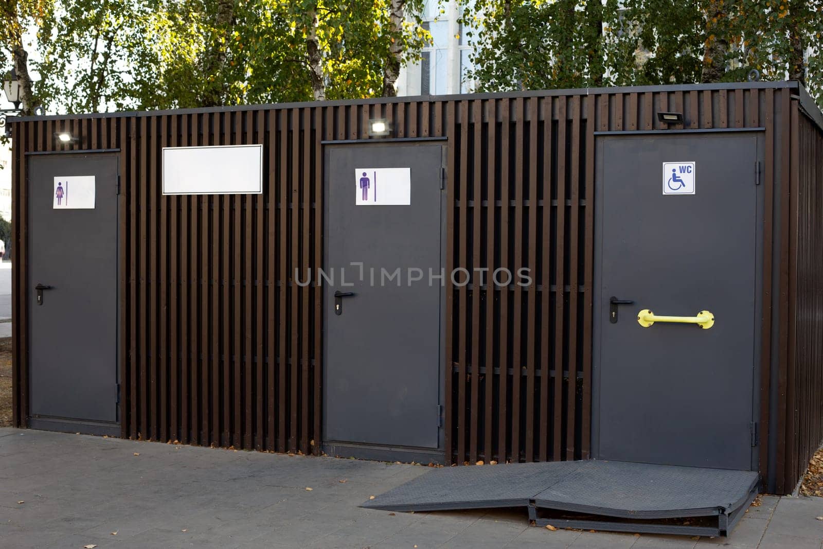 Modern public toilet on street, convenient wc for people with access for men, women and people with disabilities, accessible environment for disabled people with special ramp to toilet door