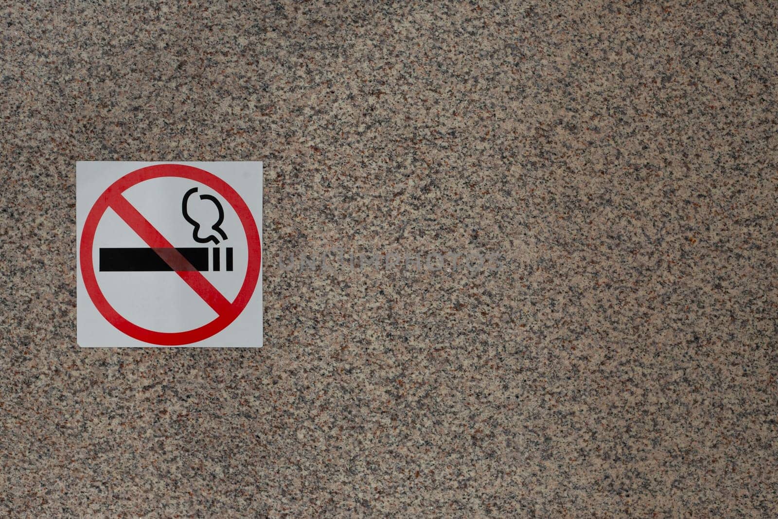 Sign prohibiting smoking in public place on wall of building, smoking ban, sticker indicating smoking free zone, social problem of smoking and fight against bad habits of people