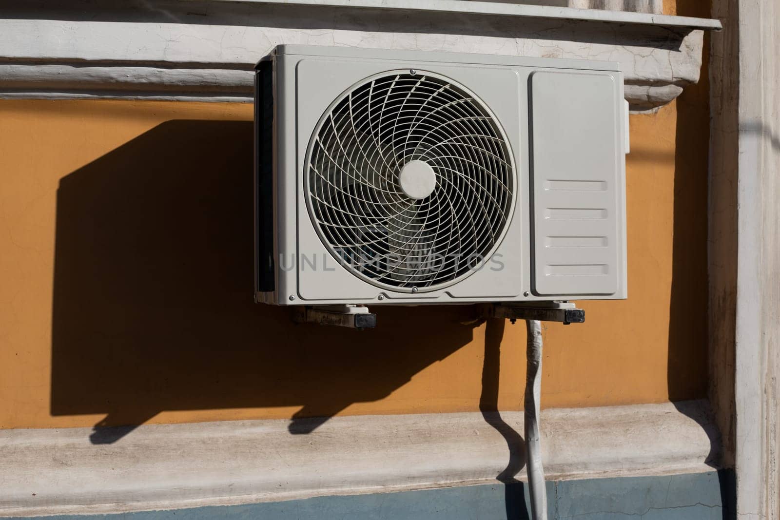 External air conditioner unit on building, close up photo of gray air conditioner on facade of house, changing and controlling temperature of house on hot day using equipment