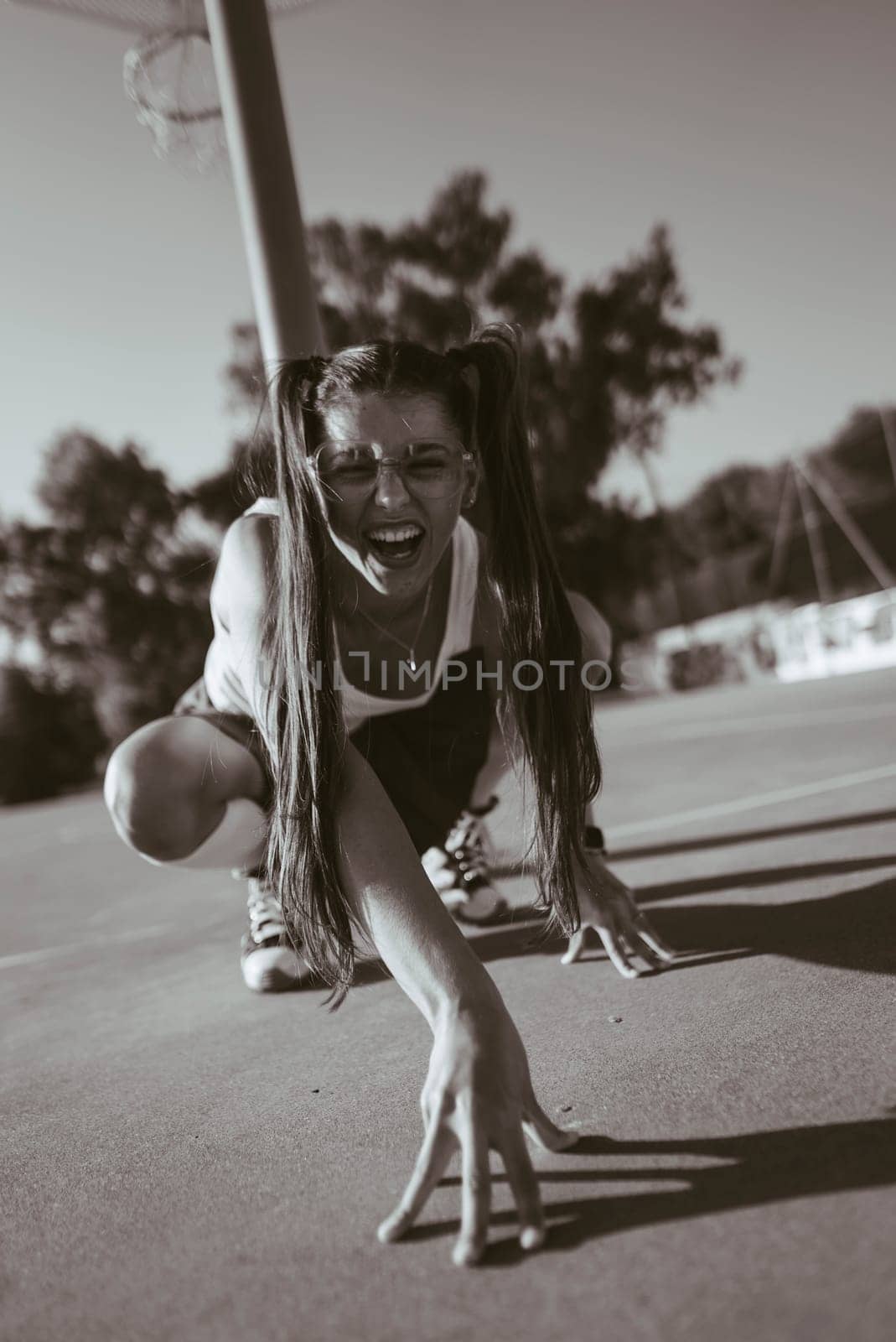 A striking black and white photograph captures a performer showcasing remarkable and dramatic movement outdoors
