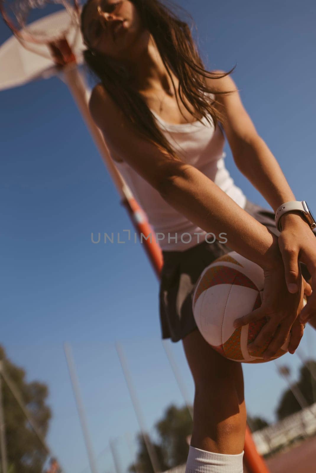An energetic and dynamic scene capturing a determined young female basketball player as she prepares to take a shot