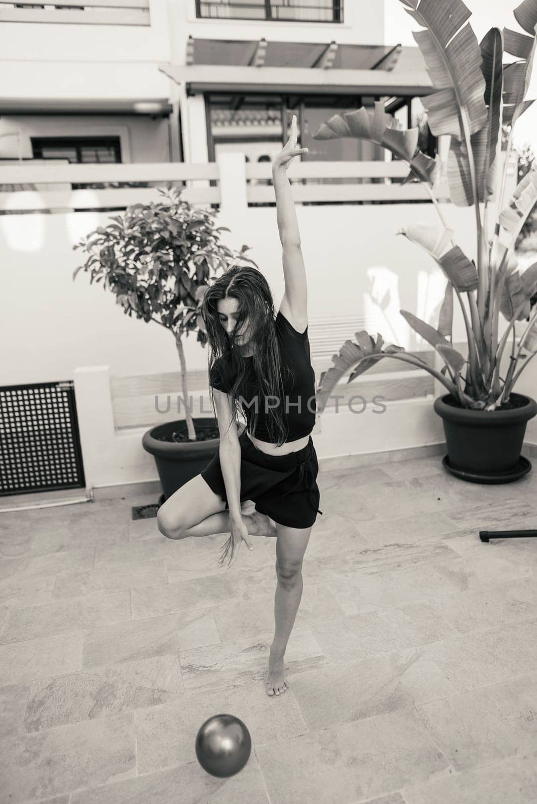 A dancer striking a powerful and dynamic pose outdoors, beautifully capturing both energy and elegance