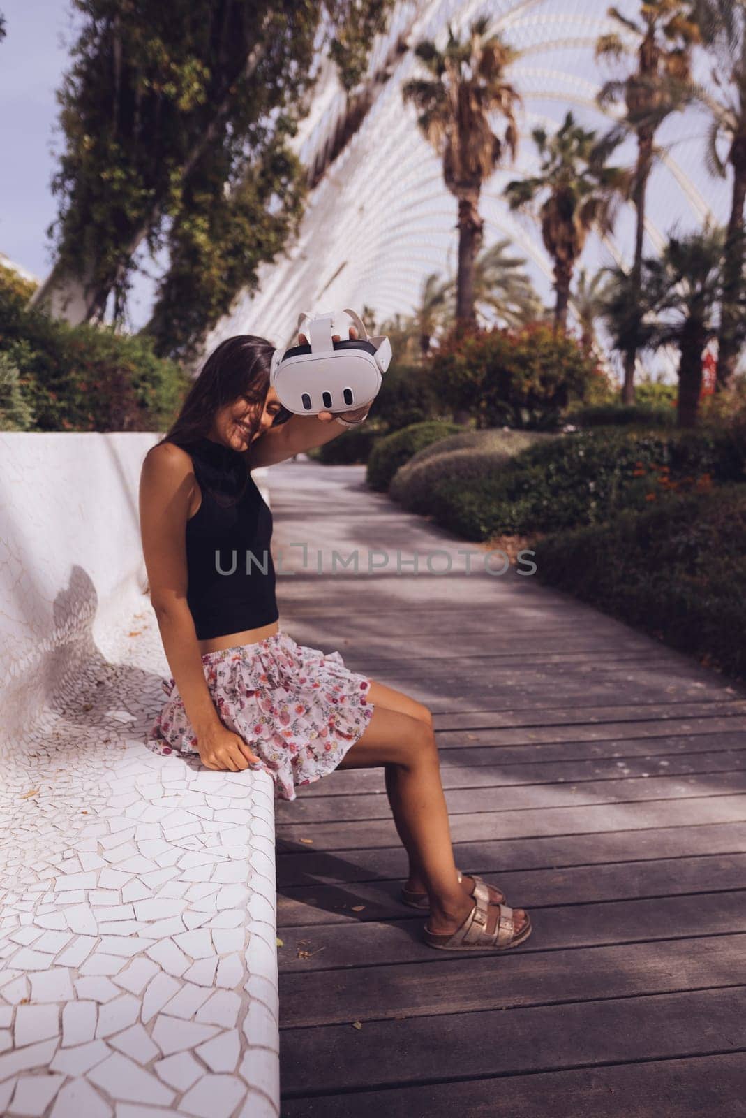A fashionable woman takes pleasure in the beauty of nature while strolling through a serene, modern park setting