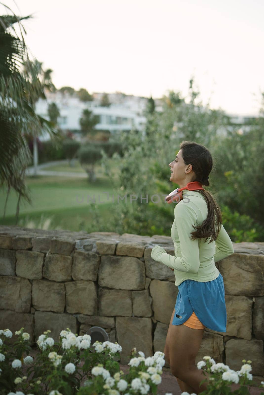 A woman jogs in a beautiful landscape, showcasing her commitment to a healthy lifestyle and fitness