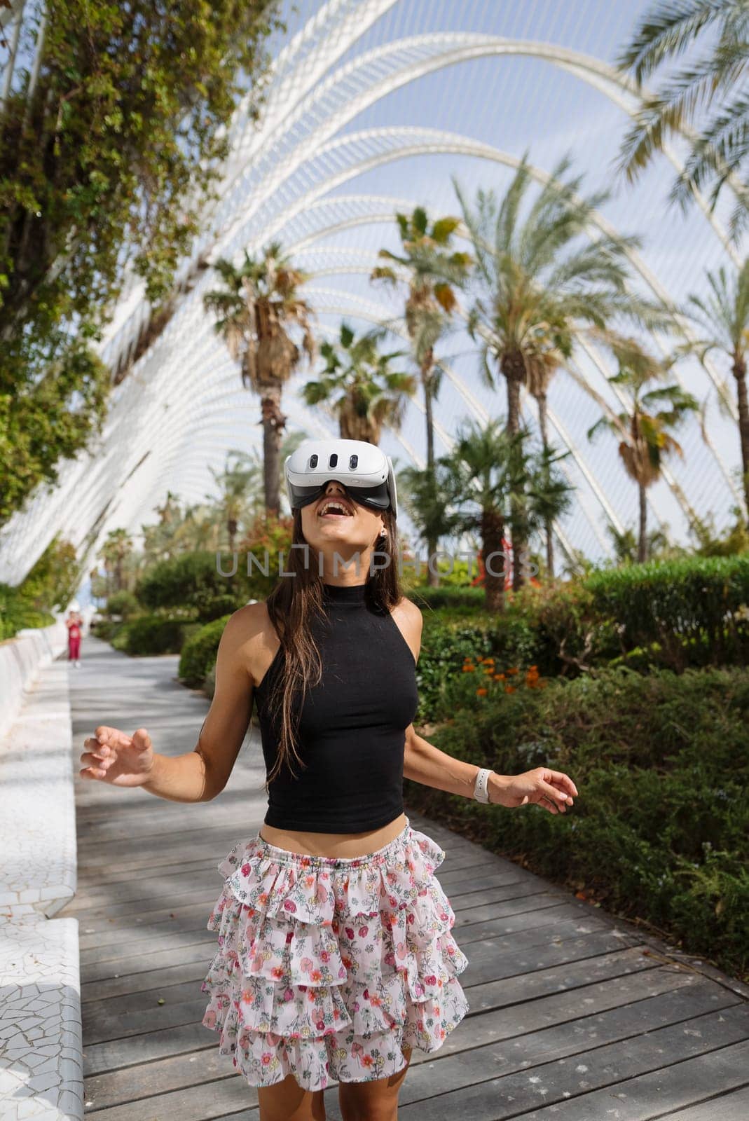 A cheerful young woman in a stylish and trendy outfit glides gracefully while skating among lush palm trees
