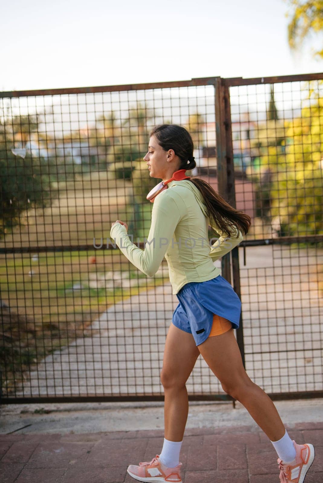 A fit woman jogging outside in her athletic wear, showcasing a vibrant and energetic lifestyle filled with activity