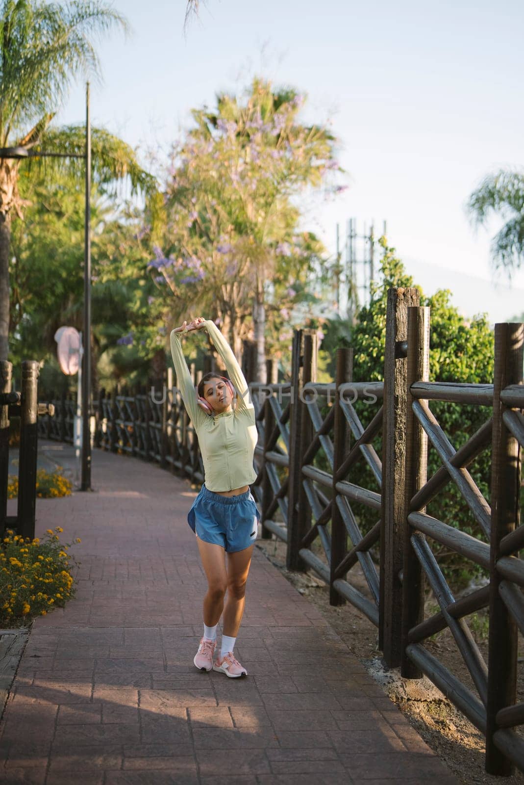 A joyful person dances enthusiastically on a beautiful, scenic pathway that is surrounded by lush greenery