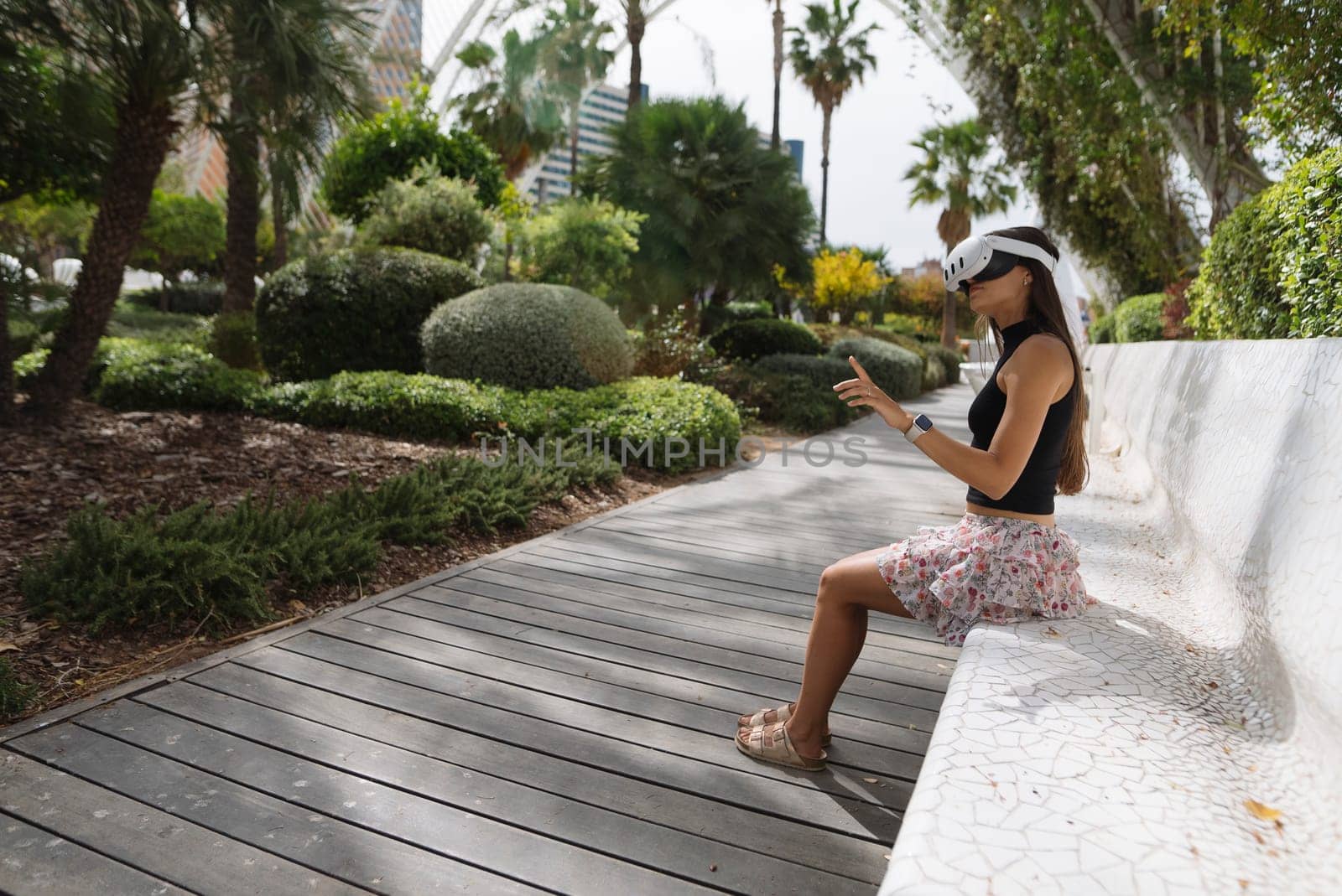 A woman finds happiness as she enjoys a peaceful moment outdoors, enveloped by vibrant greenery in a stylish setting