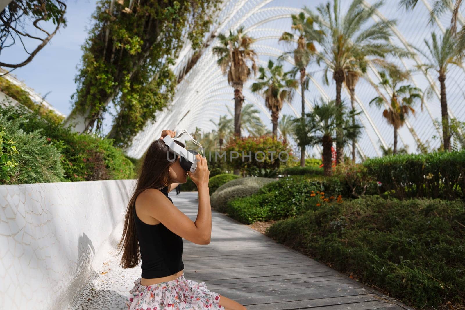 A young woman takes a journey through a vibrant, lush garden while donning a virtual reality headset