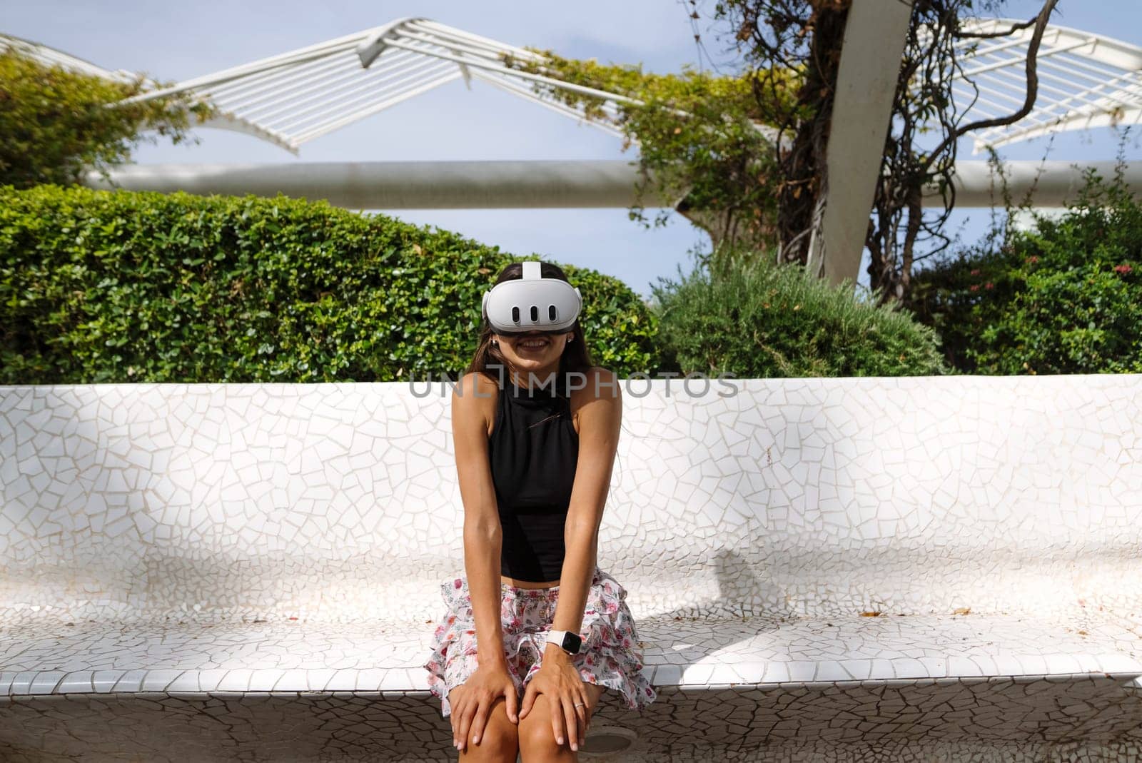 A young woman, fully immersed in the world of virtual reality, enjoys engaging with technology and nature outside