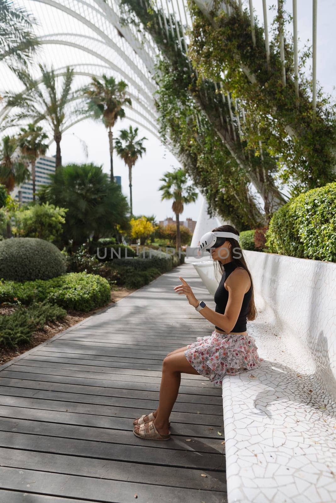 A young woman is happily enjoying a serene and peaceful moment in a vibrant lush garden filled with tropical plants