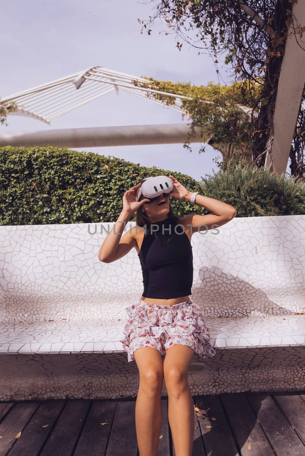 A fashionable young woman is relishing a beautiful sunny day outdoors while showcasing her unique and stylish outfit