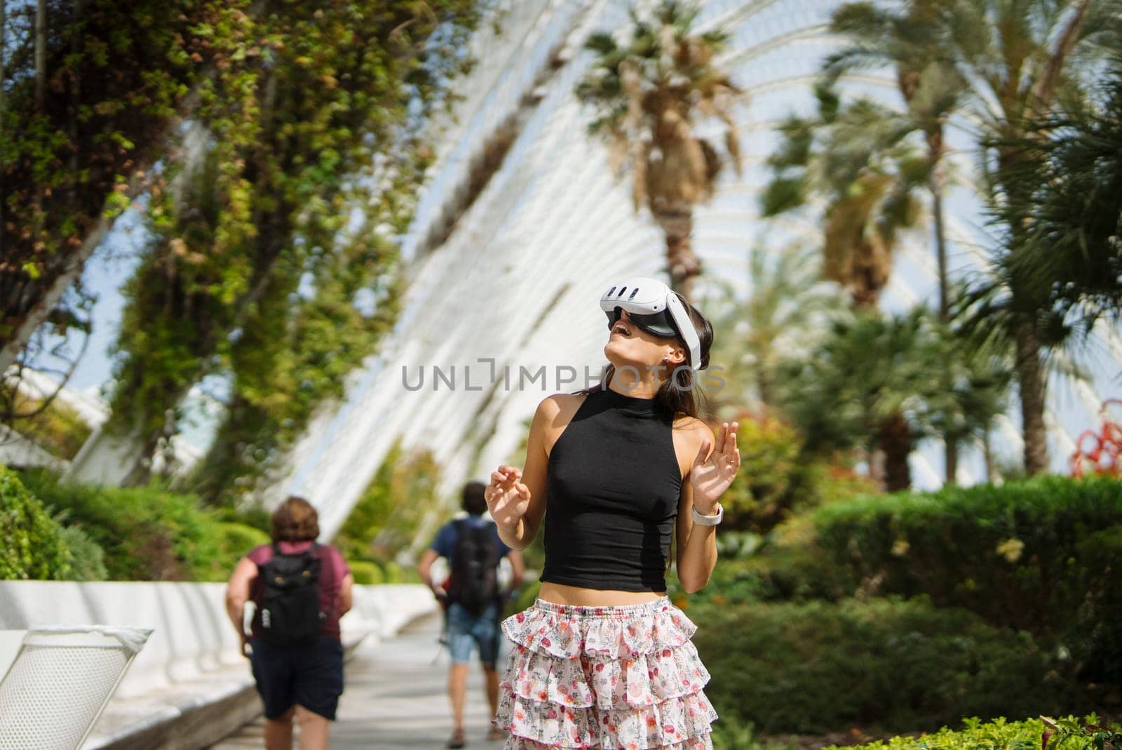 A trendy young woman poses confidently amidst the lush tropical greenery in a highly vibrant environment