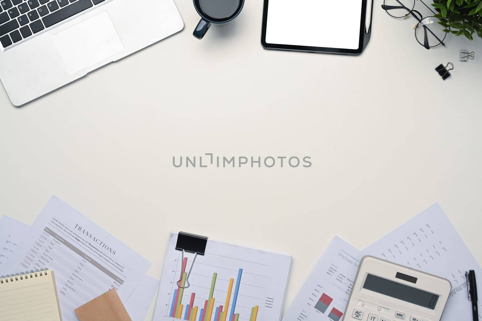 Top view digital tablet with empty display, laptop and financial document on white table.