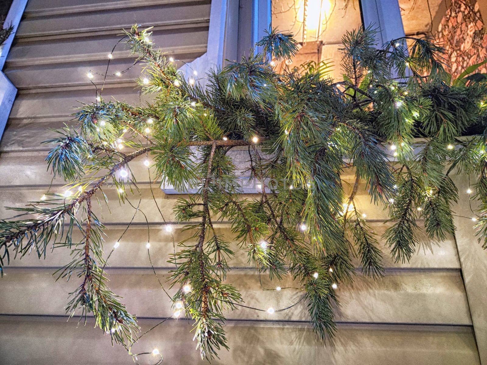 Festive pine branches adorned with twinkling lights enhance the charm of a home during the holiday season.