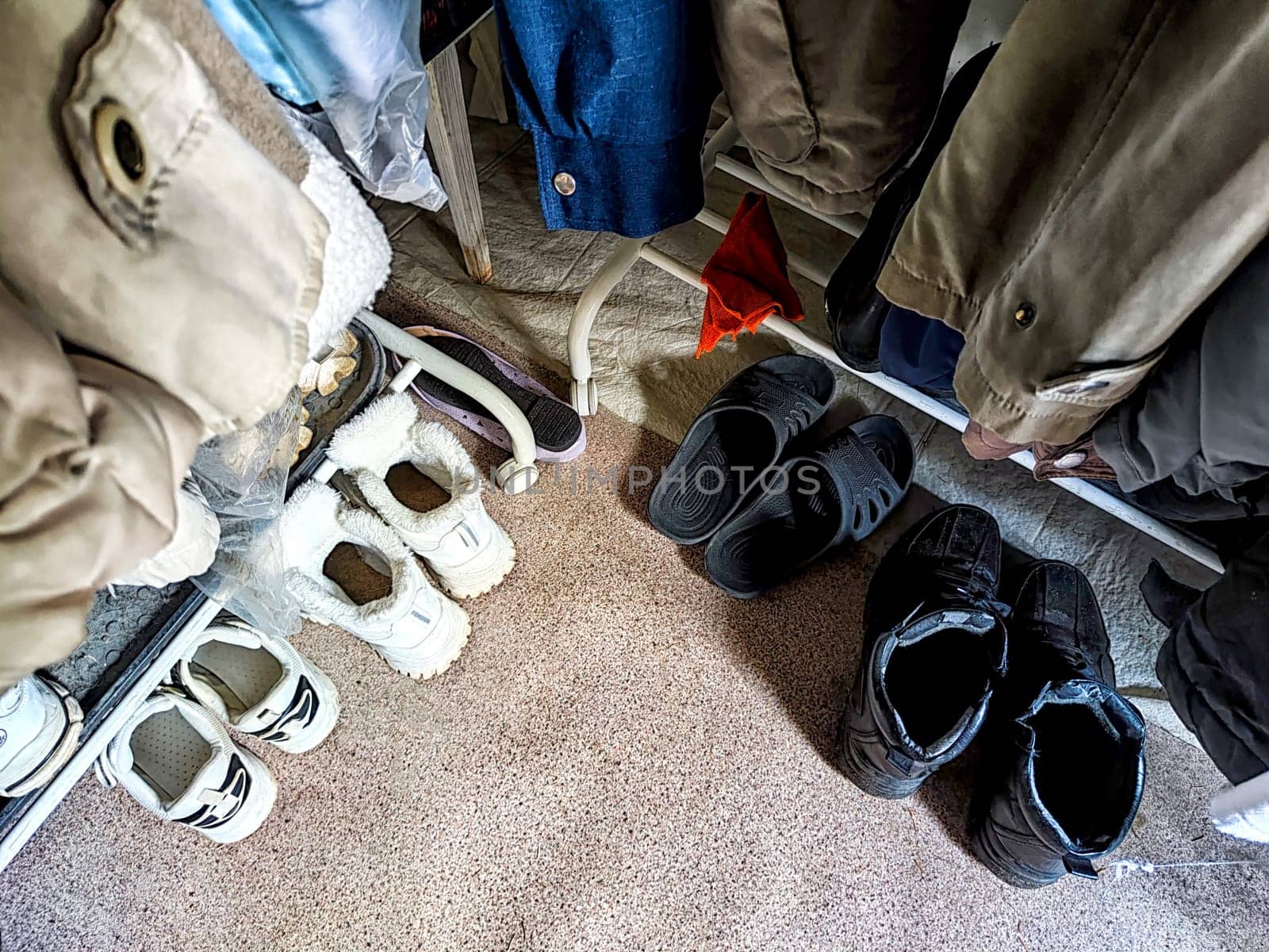 Various shoes and clothing hang neatly in a well-organized closet.
