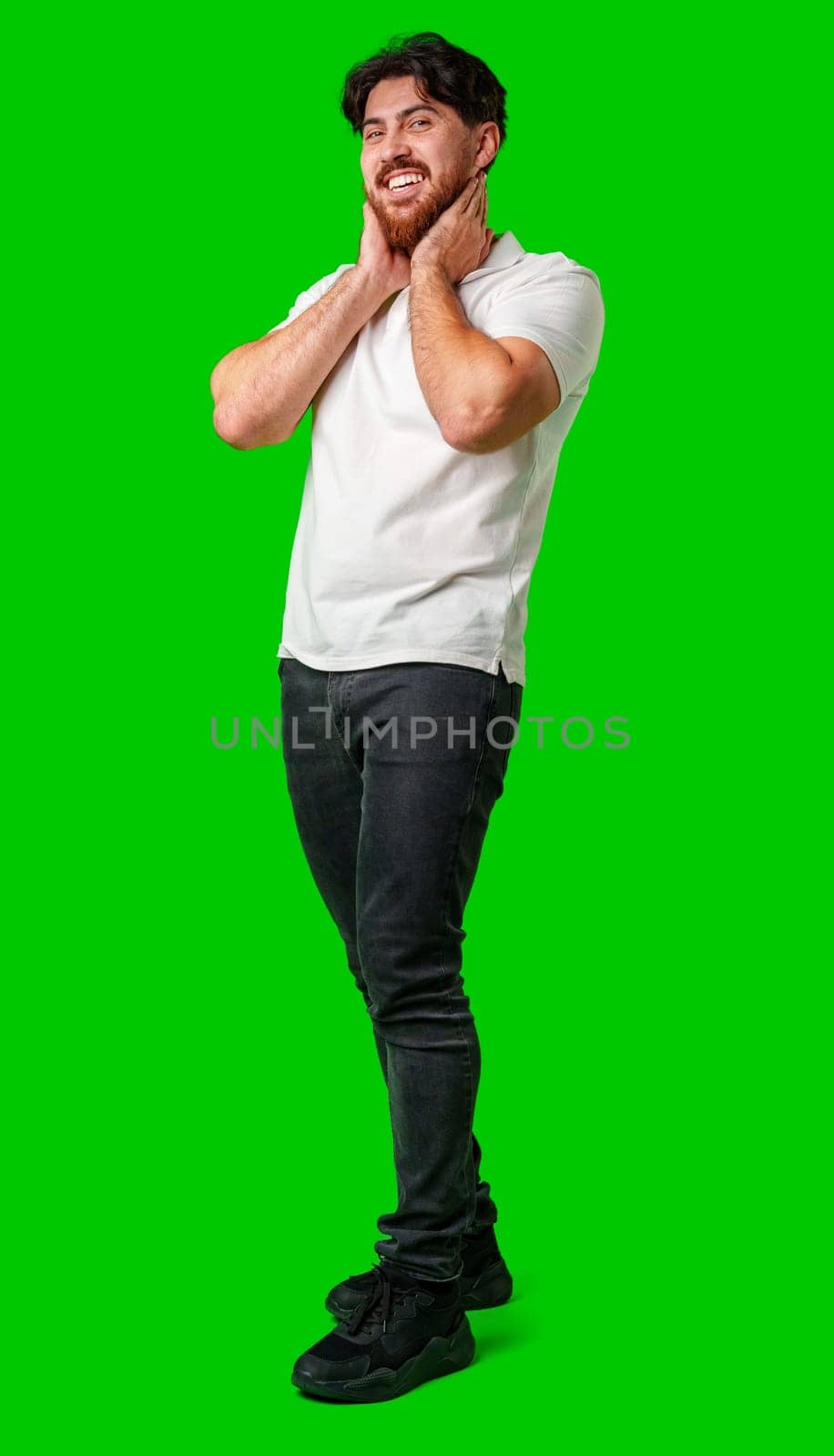 A man with a beard smiles confidently against a bright green background close up