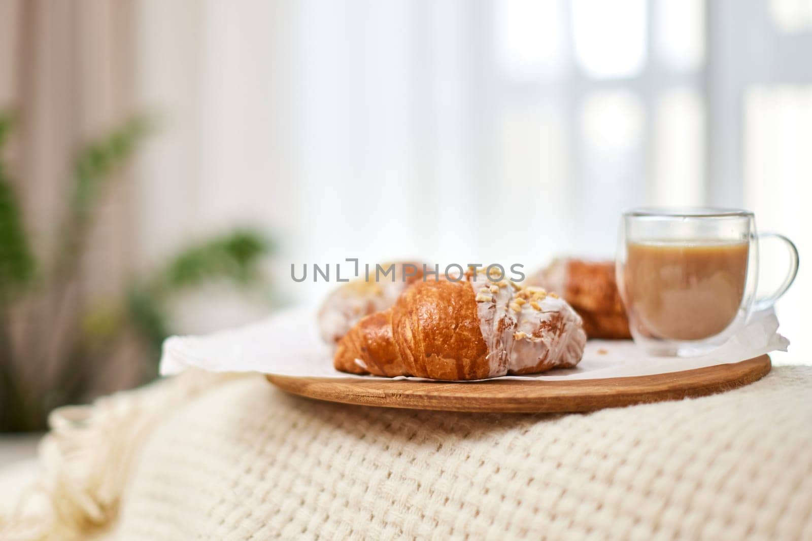 Delicious fresh french croissants and glass of coffee on wooden tray for breakfast in bed in the morning, tasty breakfast