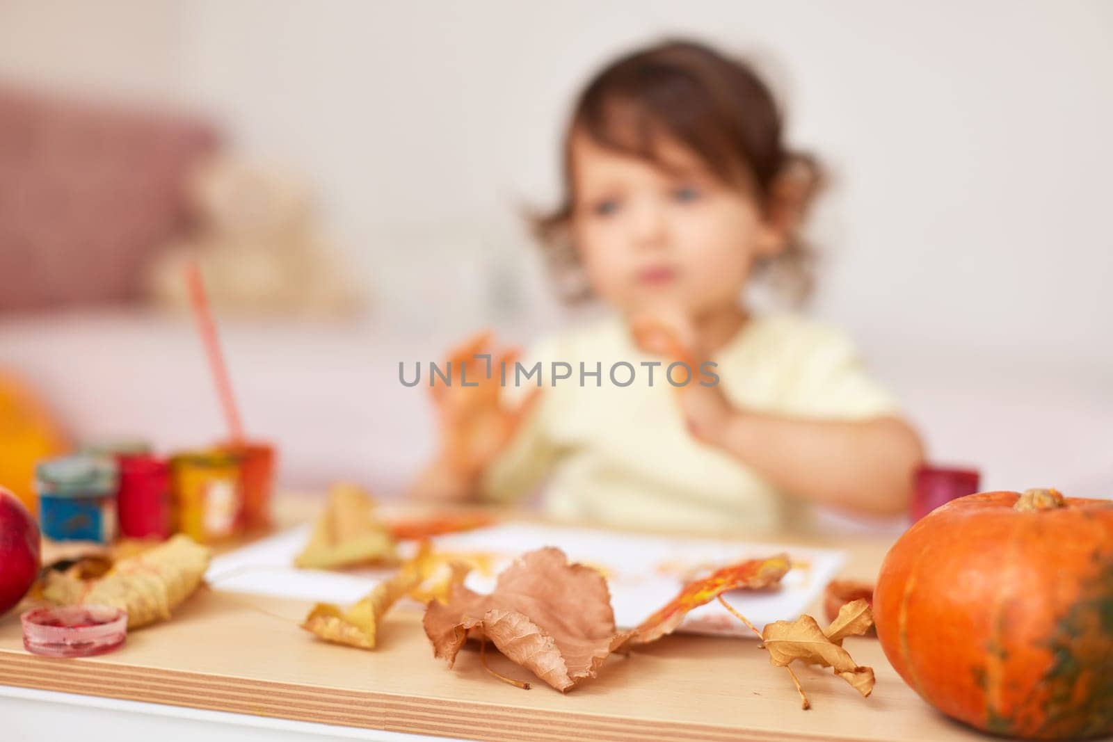 autumn background. happy little child girl painting autumn leaves. focus on leaves