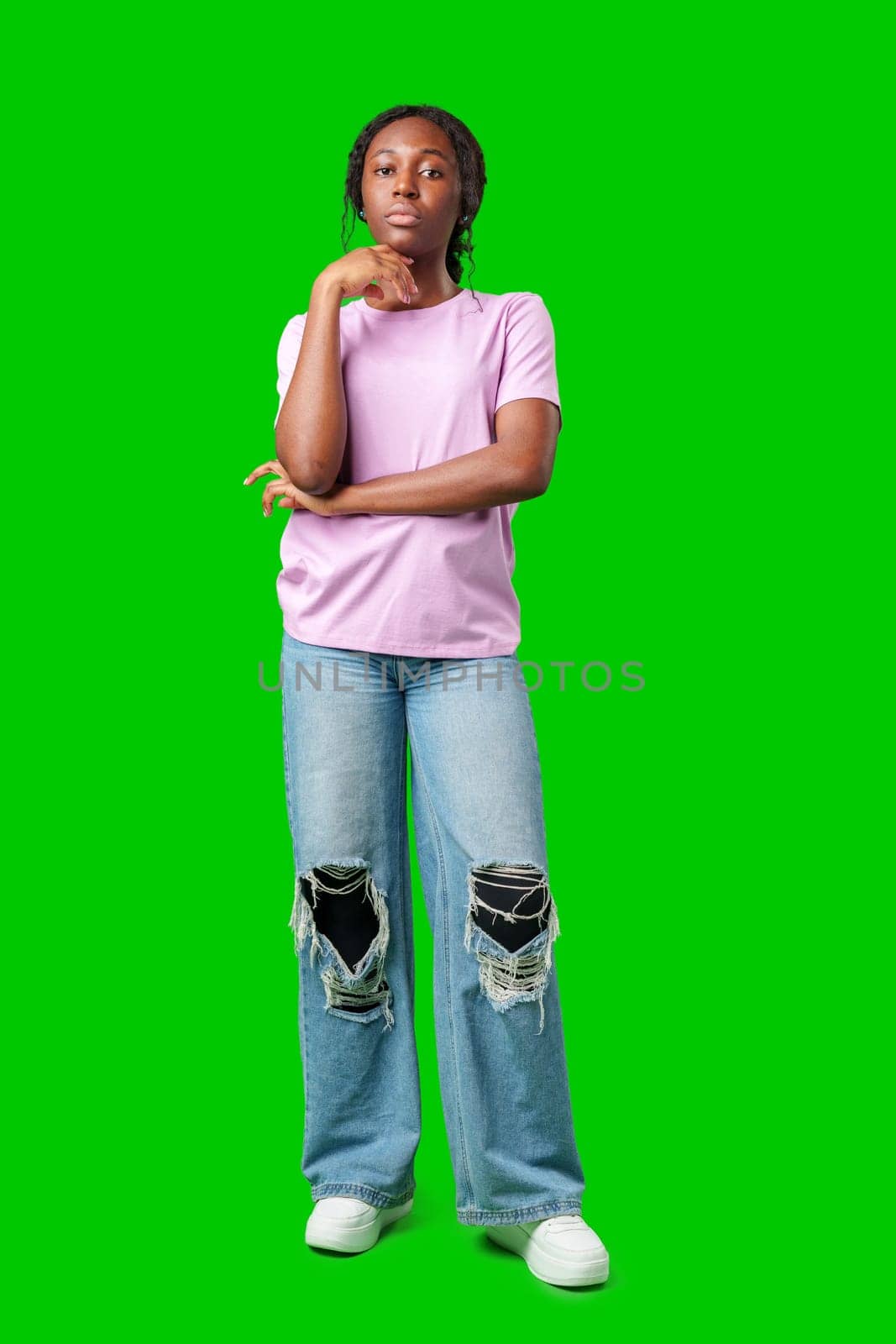 Thoughtful woman pondering in front of a bright green background during a casual moment close up