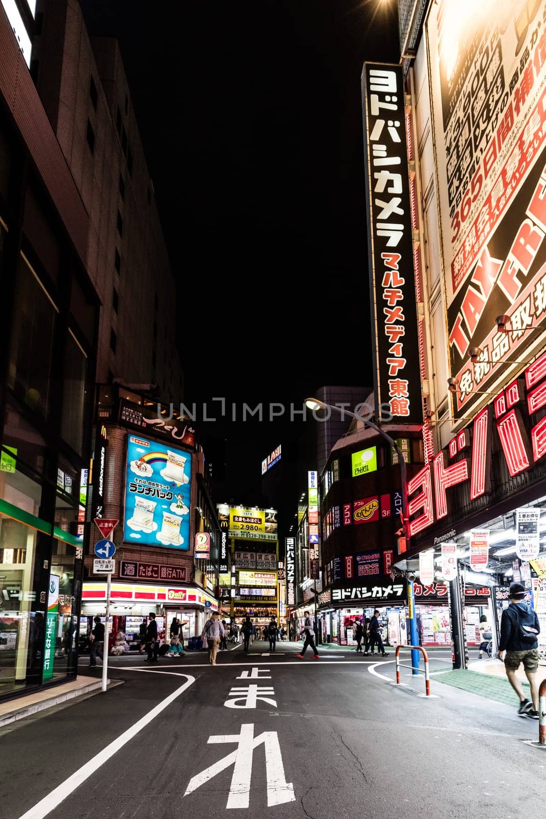 TOKYO, JAPAN - MAY 12 2019: Neon signs illuminate Tokyo’s busy Shinjuku neighborhood at night around Yodobashi camera store