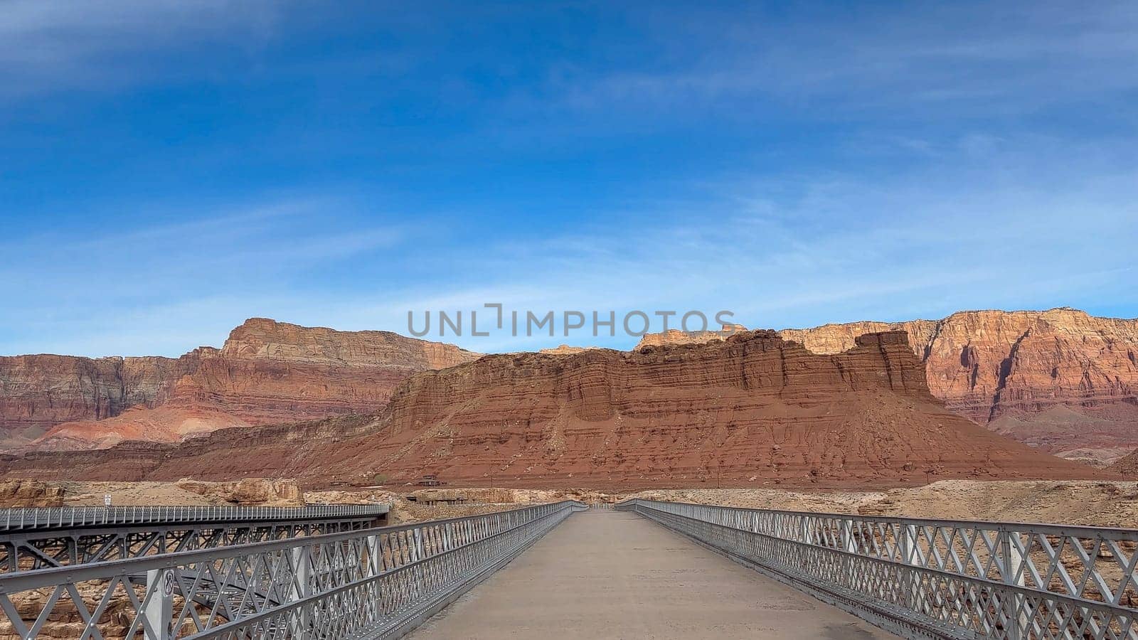 View across the old historic Navajo Bridge at Marble Canyon across the Colorado River. The stunning Vermillion Cliffs can be seen on the other side of the bridge - Arizona, USA