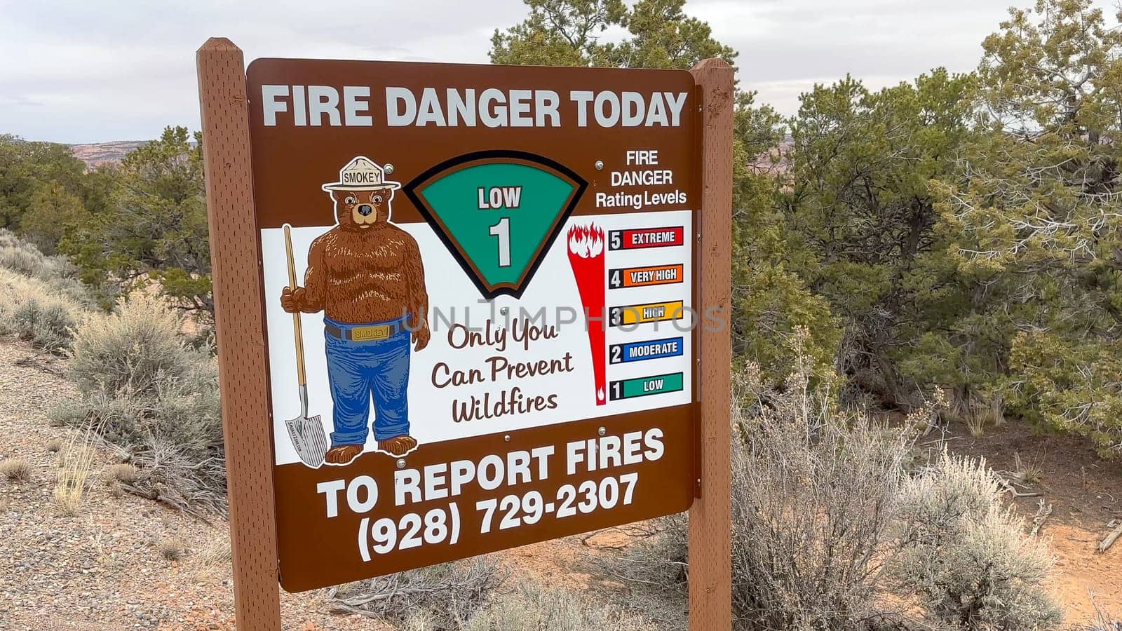 Kayenta, Arizona, USA - 03.12.2024: Smokey the Bear on a sign indicating a low fire danger in the desert landscape of Arizona, USA. This evokes a sense of safety and caution during wildfire season.