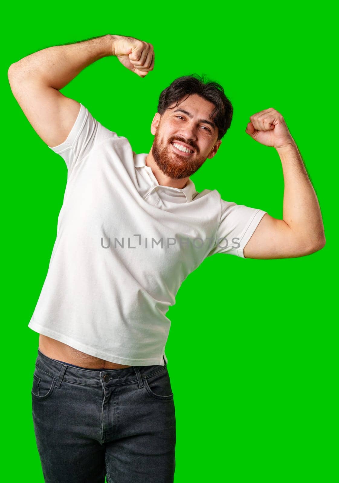 Happy man celebrating success with raised fists, wearing a white shirt against a bright green background close up