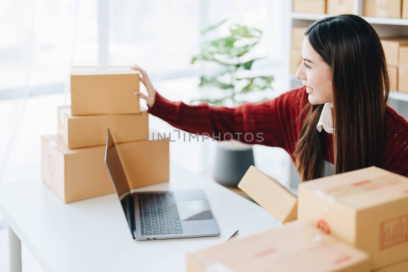 Asian female business owner handles delivery of orders to customers.