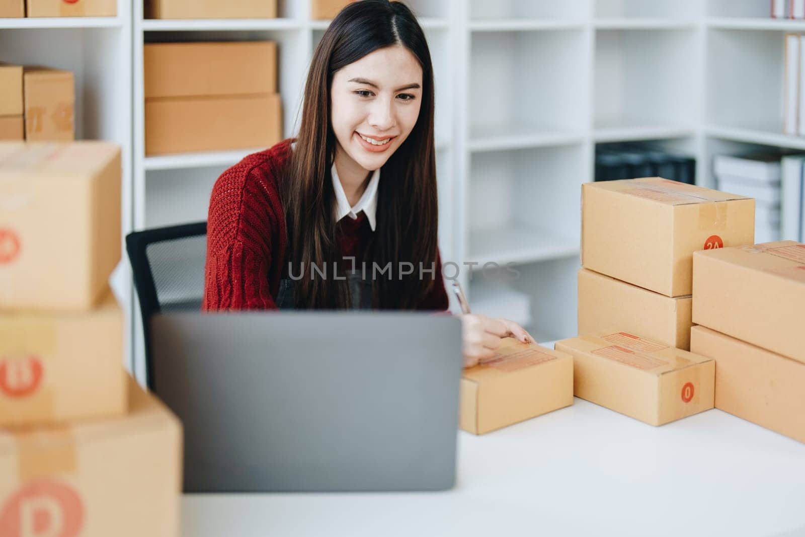 Asian female business owner handles delivery of orders to customers.