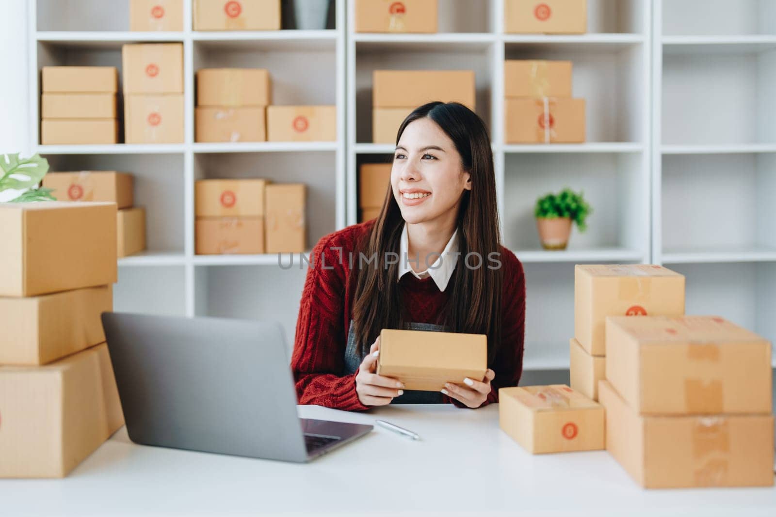 Asian female business owner handles delivery of orders to customers by Manastrong