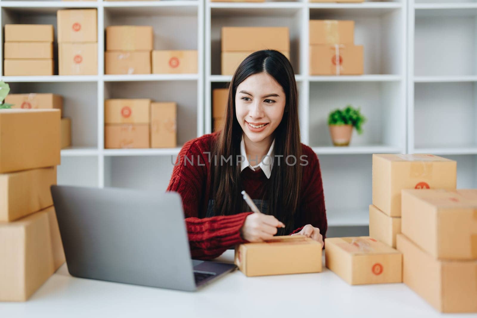 Asian female business owner handles delivery of orders to customers by Manastrong