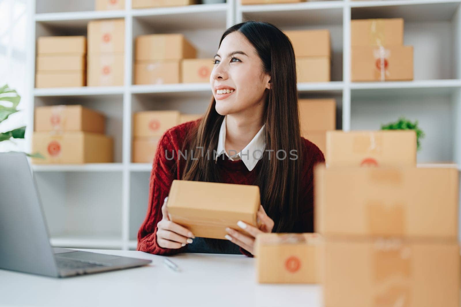 Asian female business owner handles delivery of orders to customers by Manastrong