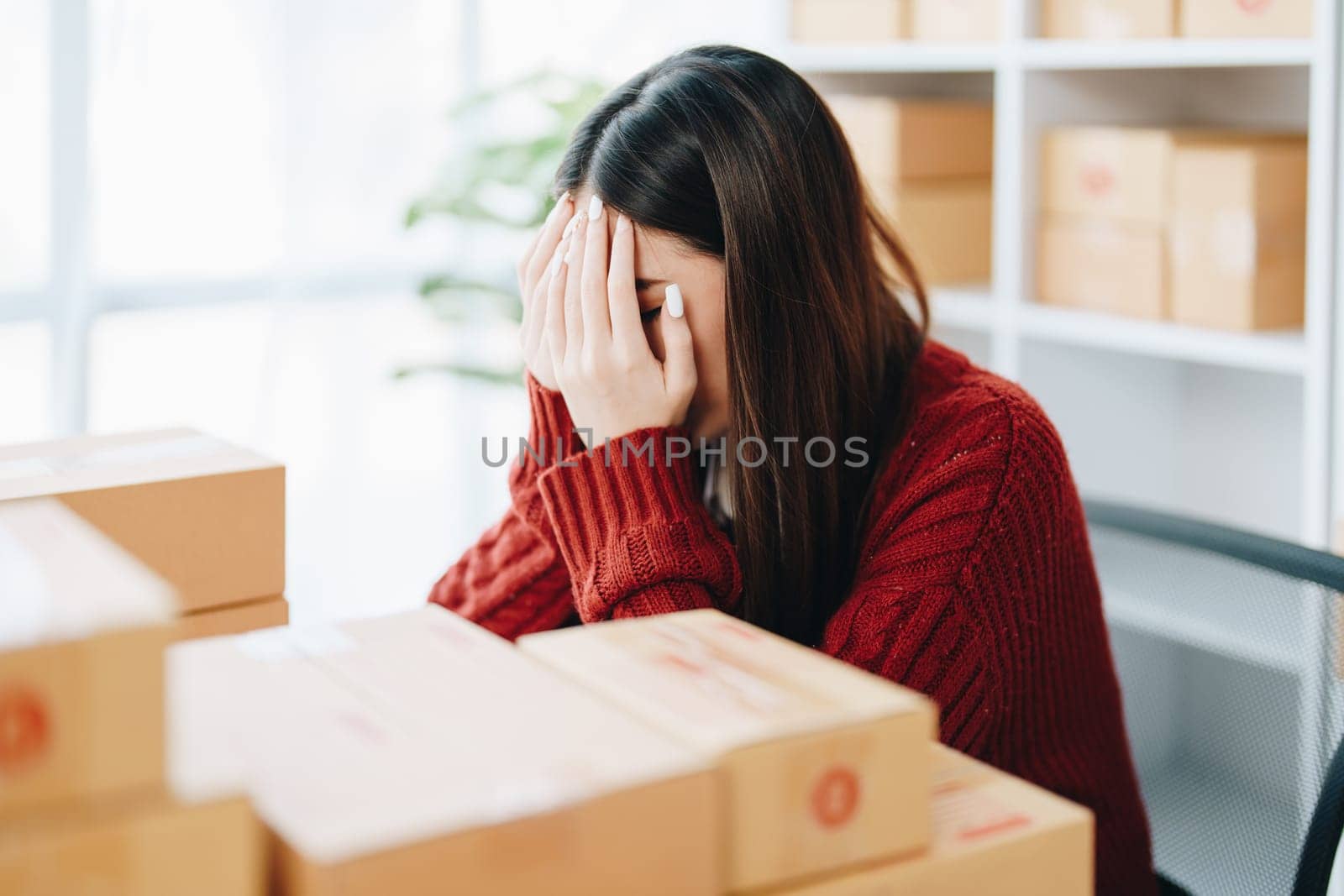 Starting small business entrepreneur of independent Asian woman showing her face worried about the sales of her business not reaching the target set. SME concepts.