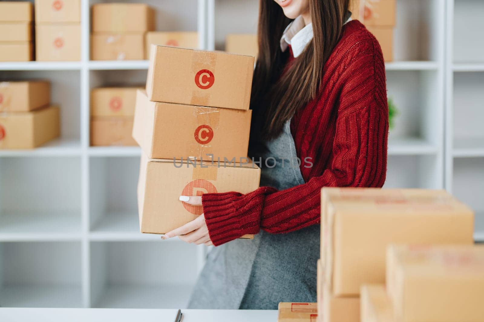 Asian female business owner handles delivery of orders to customers.