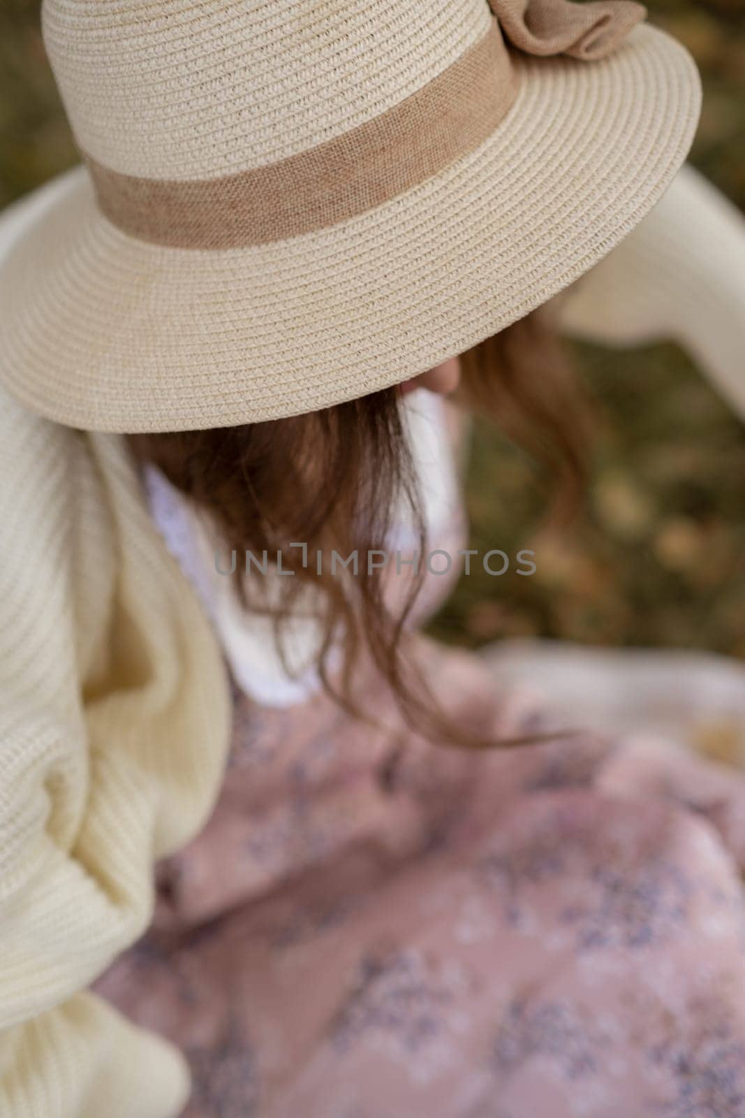 A young beautiful woman in a dress and a round hat reads a book by AnatoliiFoto