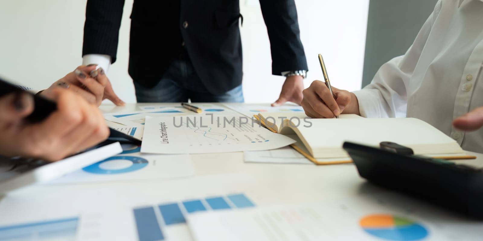 Business team analyzes financial business finance reports on laptop and graph documents during corporate meeting discussion showing successful teamwork, business meeting ideas.