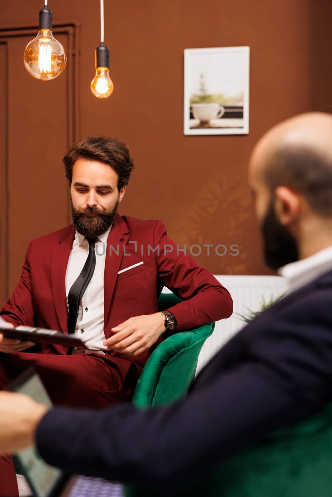 Businessmen in lounge area at hotel by DCStudio