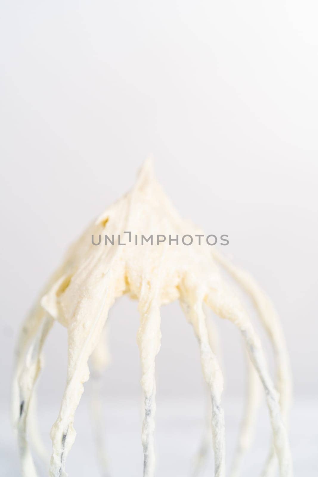 Whipping white ganache in kitchen mixer to make the white chocolate ganache frosting.