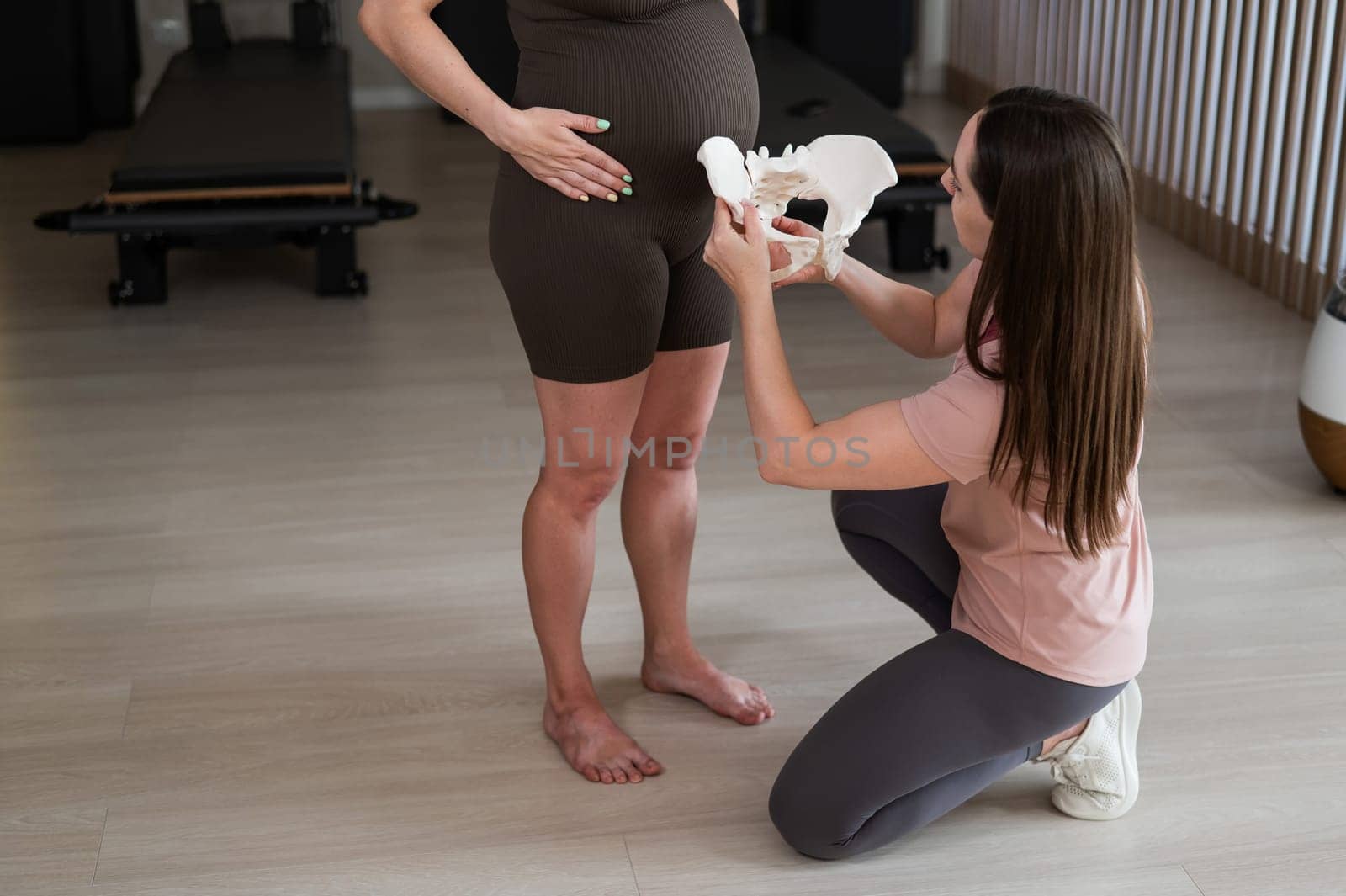 Doula explains the process of childbirth on a sample of the pelvis of a pregnant woman