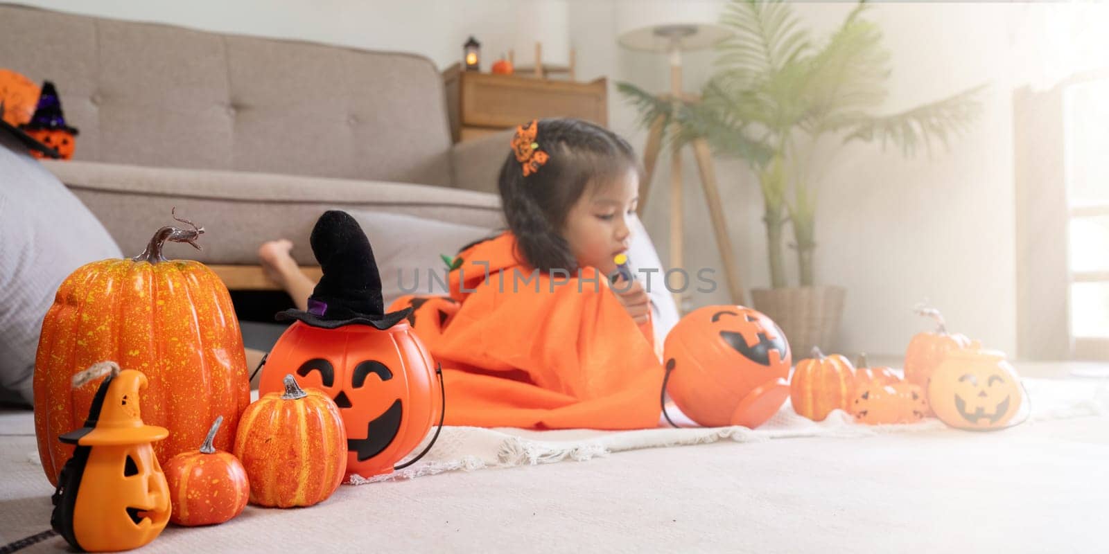 Halloween concept cute little child girl preparing to celebrate at home.