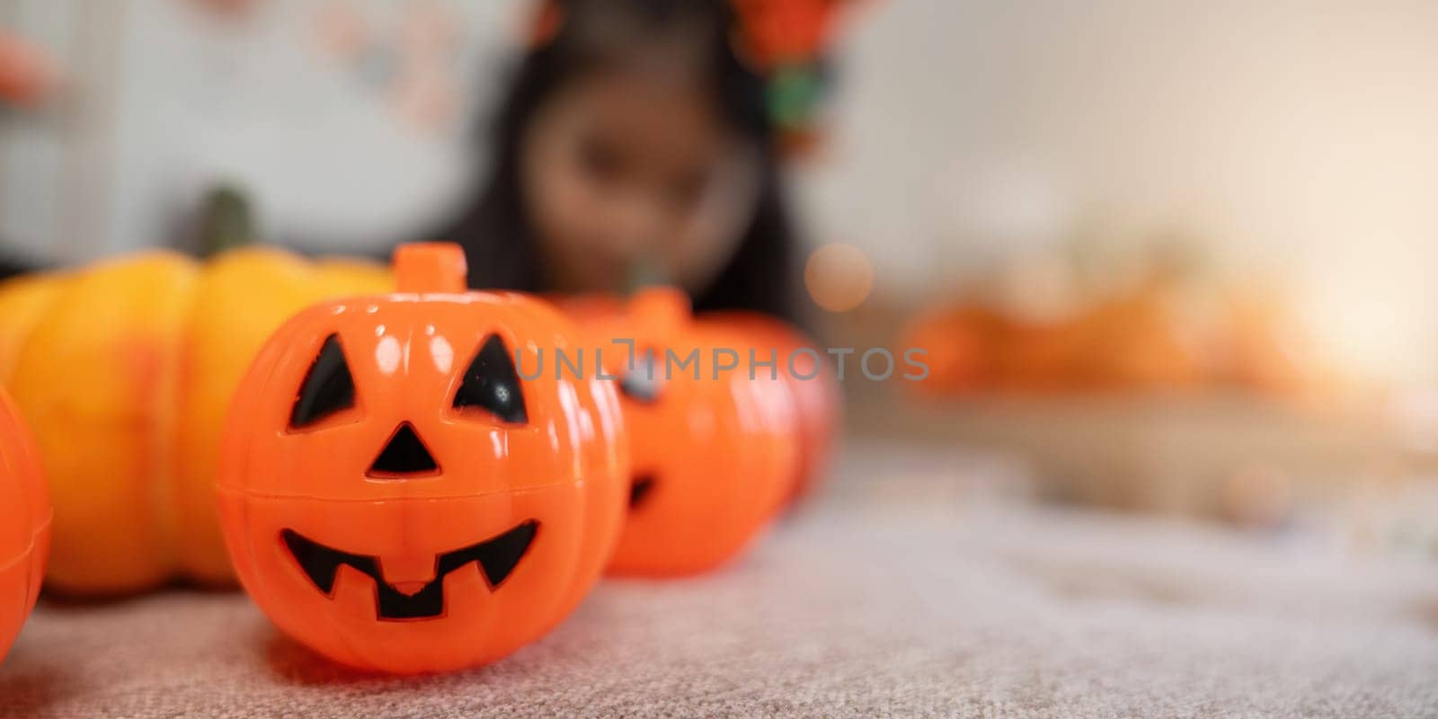 Halloween concept cute little child girl preparing to celebrate at home.