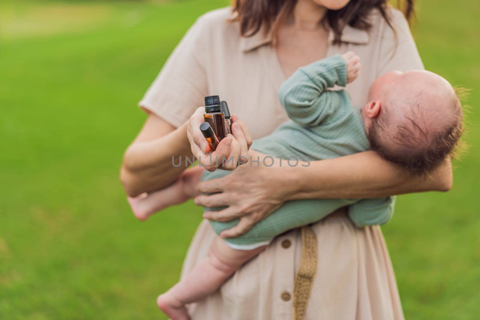 Loving mother gently applies soothing aroma oils to her precious newborn, creating a calming and nurturing atmosphere by galitskaya