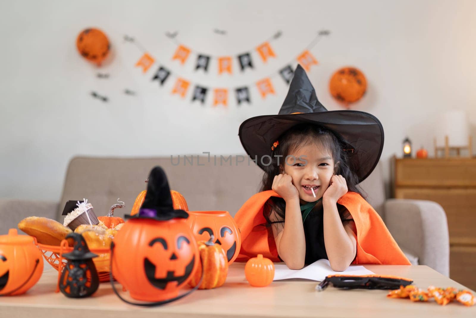 Halloween concept cute little child girl preparing to celebrate at home by nateemee
