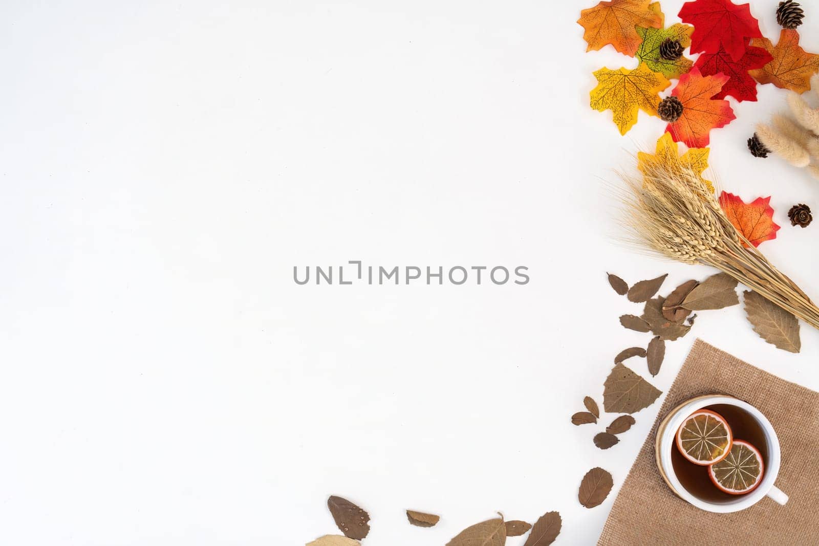 Desk workspace with blank copy space mockup, blanket, coffee cup, leaves on autumn background. work top view. seasonal autumn concept by nateemee