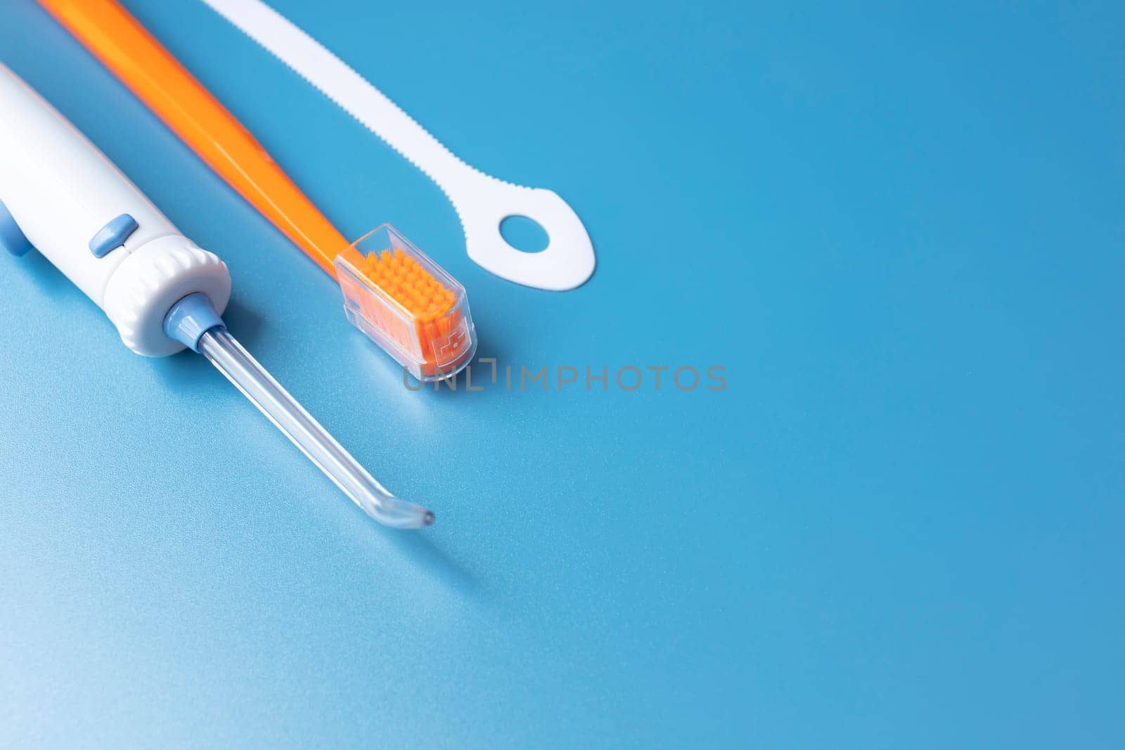 Design Dental Cleaning Set, Oral Hygiene. Toothbrush, Oral Irrigator, Floss, Tongue Scraper On Blue Background. Flat Lay Of Dental Care Tools, Tooth Hygienic Equipment. Horizontal Plane. Copy Space