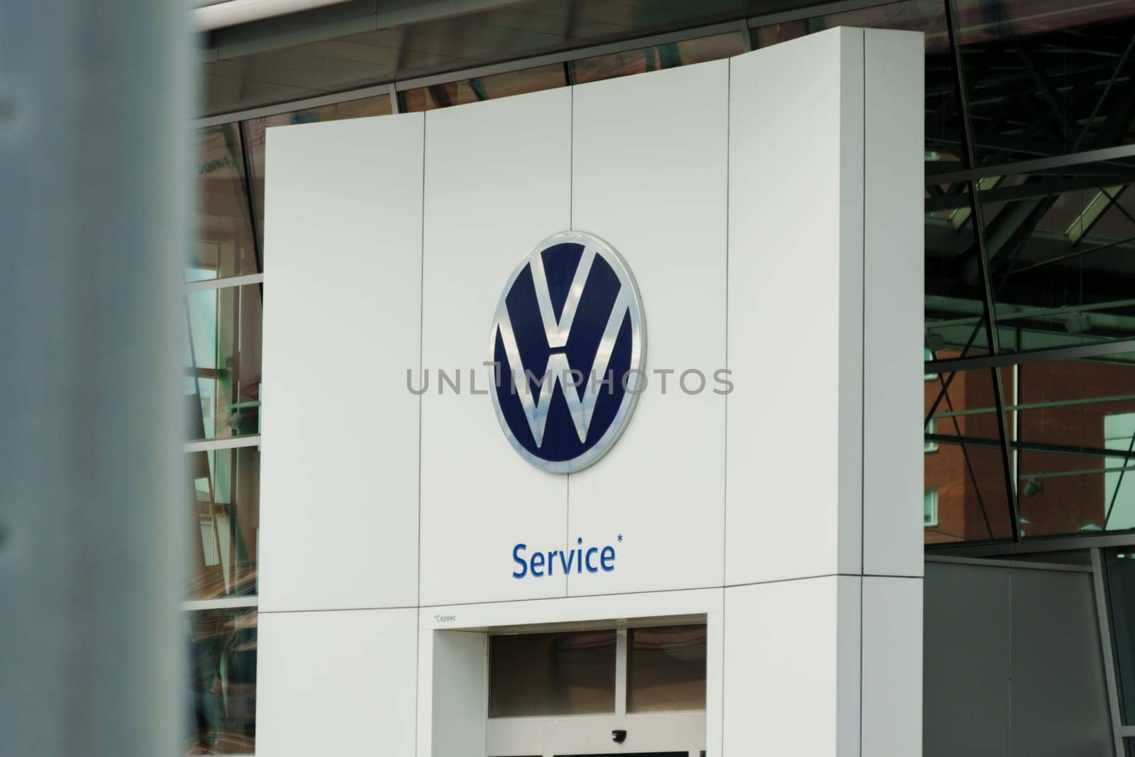 Tyumen, Russia-August 10, 2024: Volkswagen service center exterior with logo and cars parked nearby during daylight