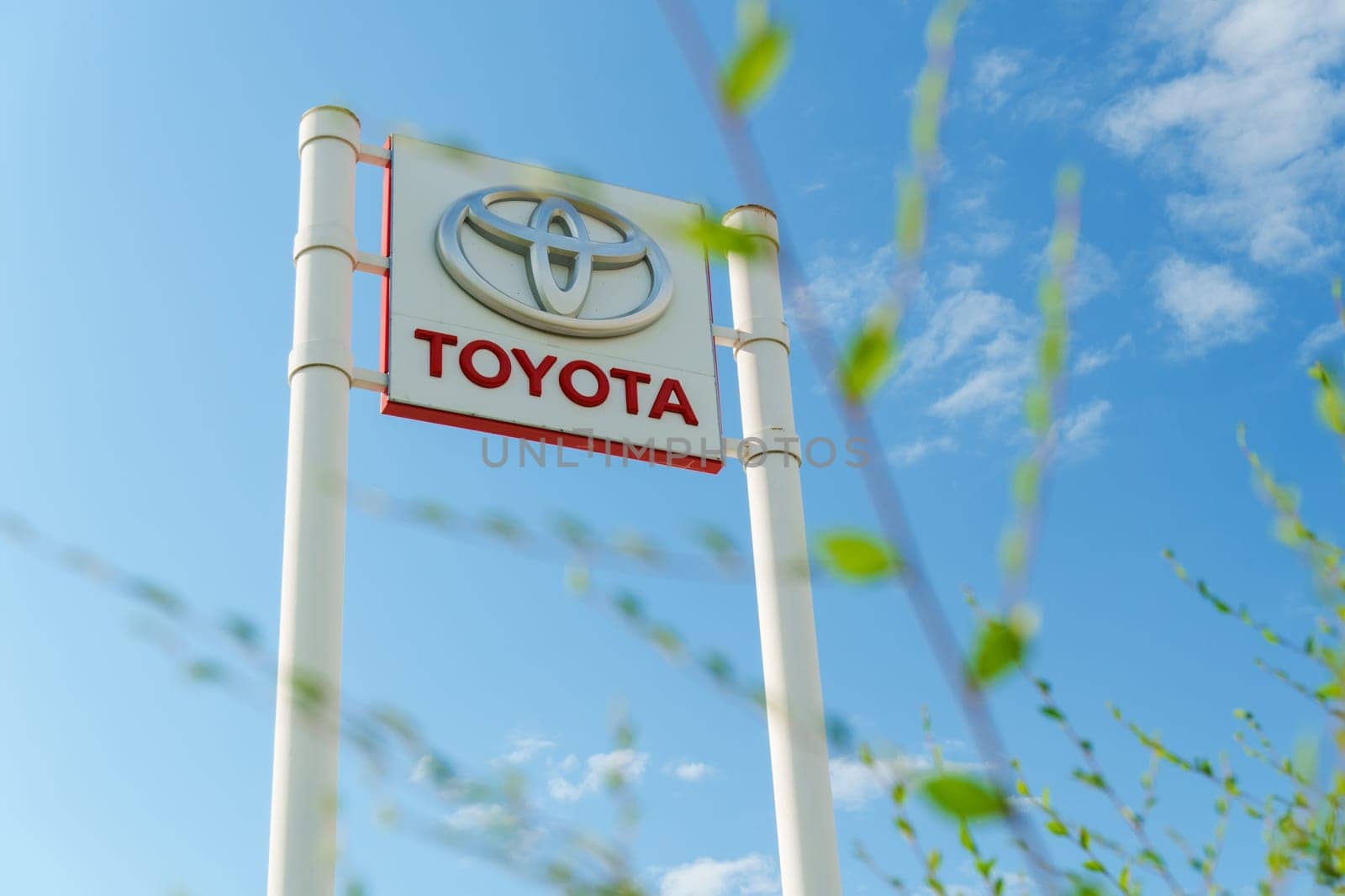 Tyumen, Russia-August 10, 2024: prominent dealership sign features the Toyota logo against a bright blue sky