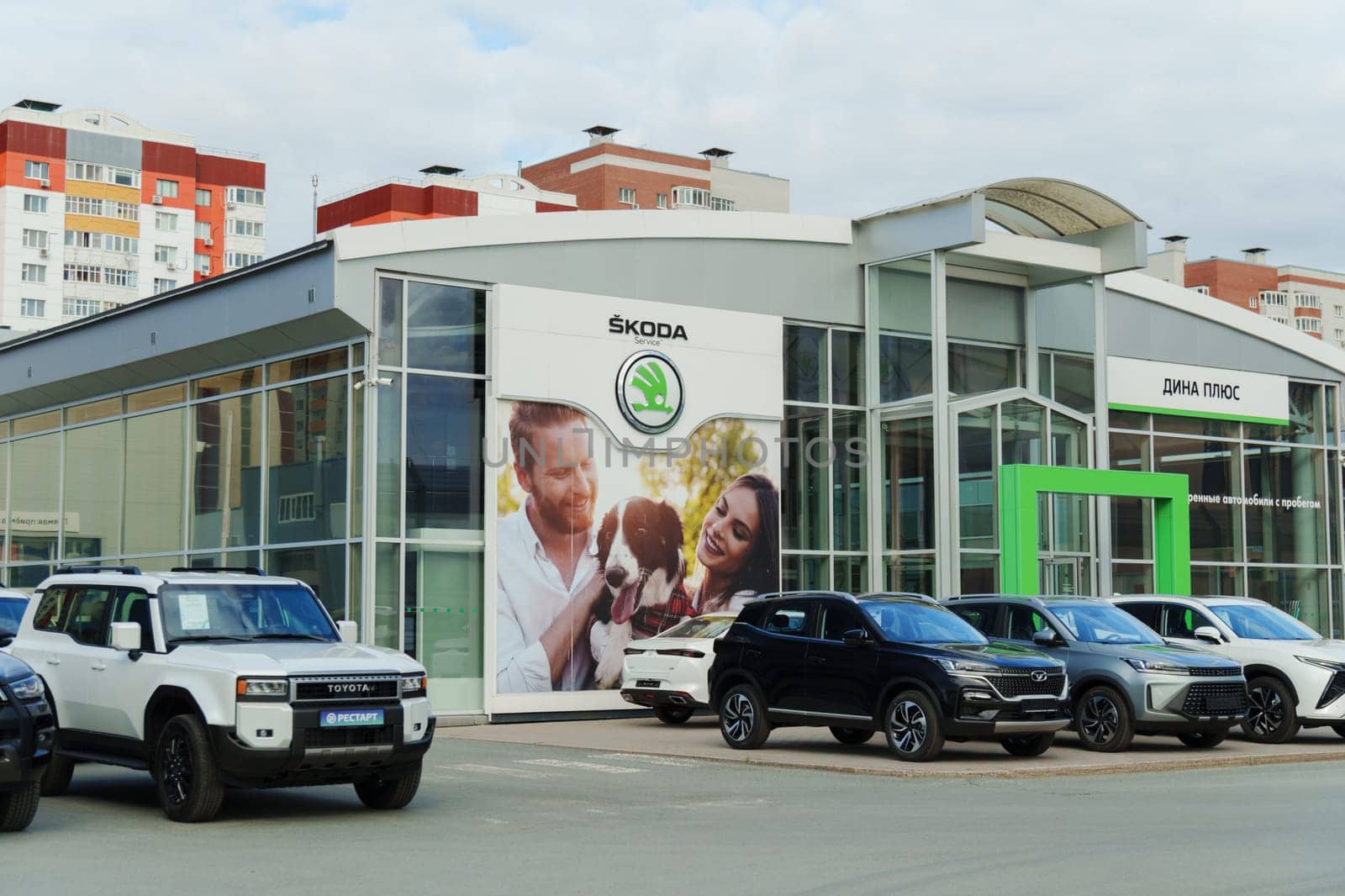 Tyumen, Russia-August 10, 2024: A tall service center sign featuring the Skoda logo and brand name, set against a backdrop of a cloudy sky