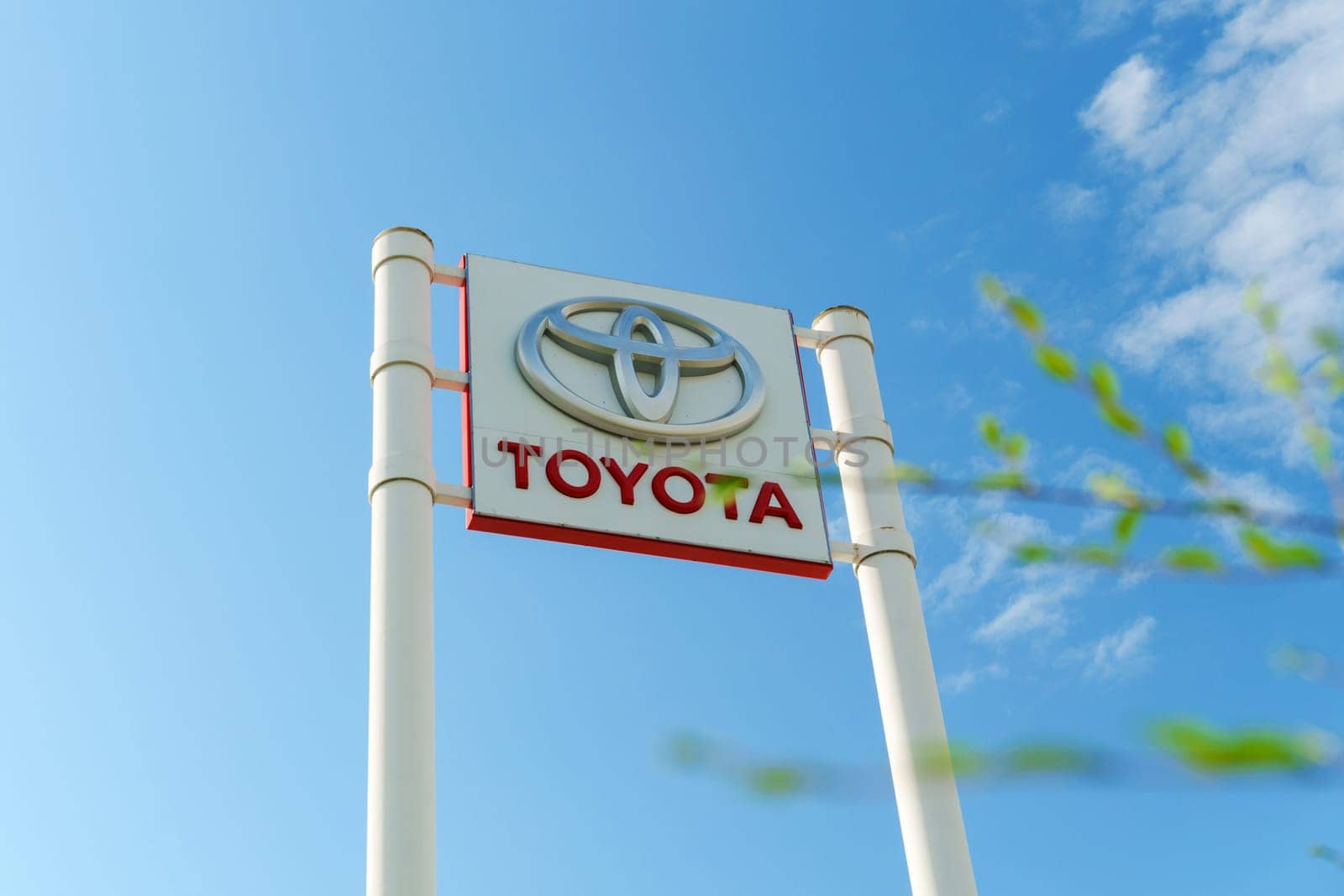 Tyumen, Russia-August 10, 2024: Toyota dealership sign under a clear blue sky with visible greenery in the foreground
